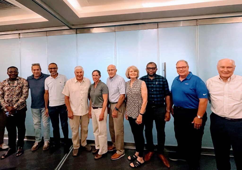 Ten people stand side by side for a group photo.