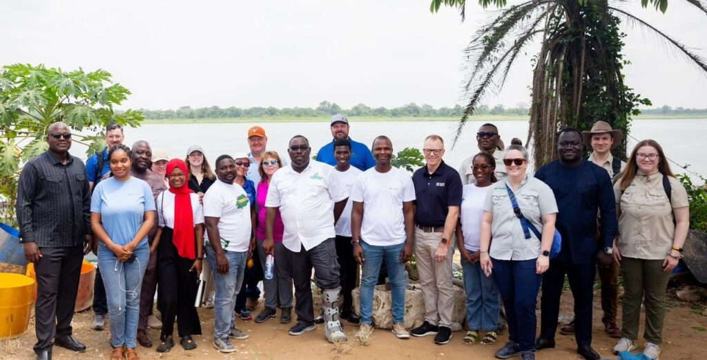 People stand in front of a lake in Ghana.